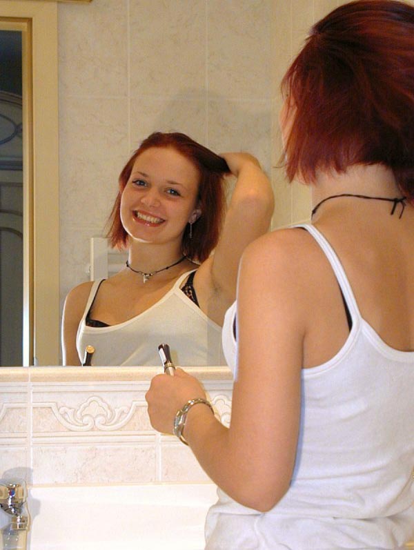 Girl grinst in den Spiegel
